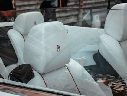 L'intérieur blanc et rouge d'une voiture avec des sièges monogrammés.