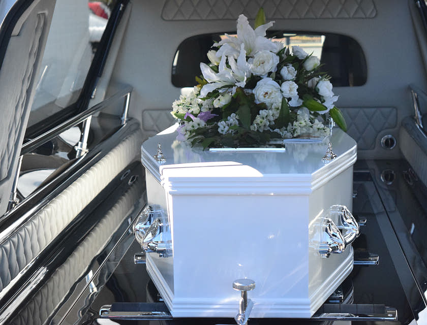Coffin with flowers inside a hearse.