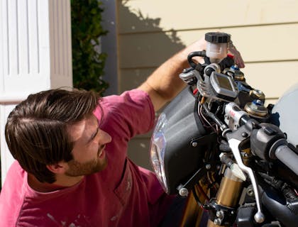 A man repairing a motorcycle.