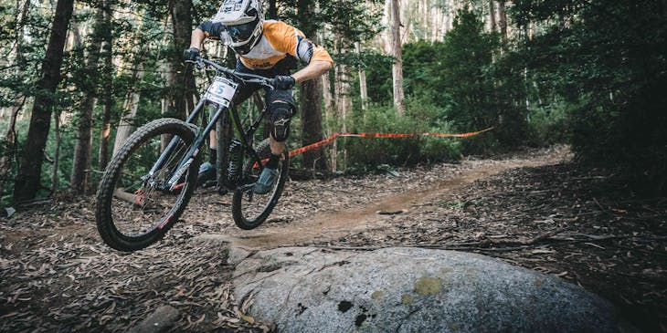 A man riding mountain bike through forest.