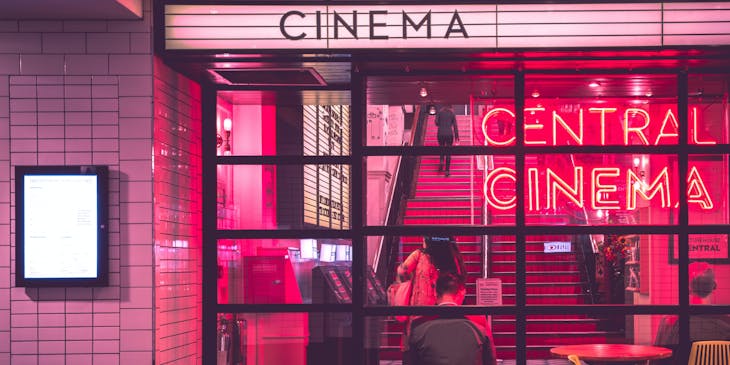A cinema foyer and staircase lit up in red.