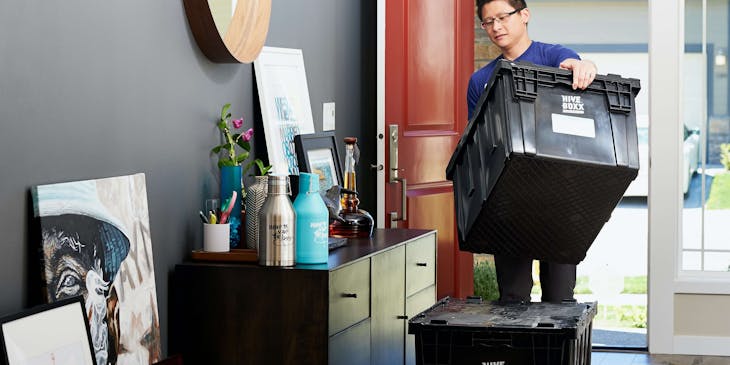 A mover moving containers of the owner's items to a new home.