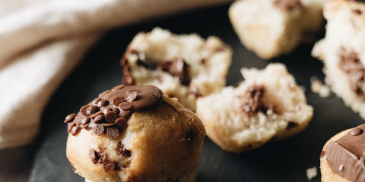 A chocolate muffin displayed on a wooden table.
