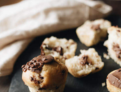 A chocolate muffin displayed on a wooden table.