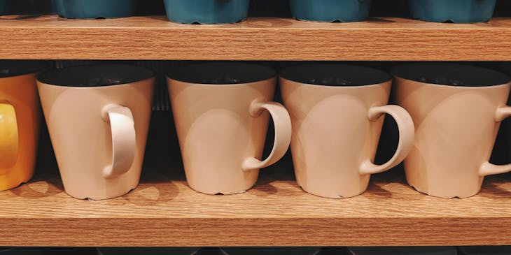 Colorful mugs on a shelf.