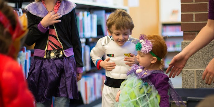 Children at a daycare while dressed in costumes.