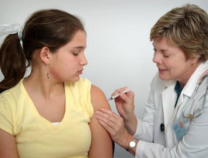 Uma médica injetando vacina em uma paciente em um centro médico.