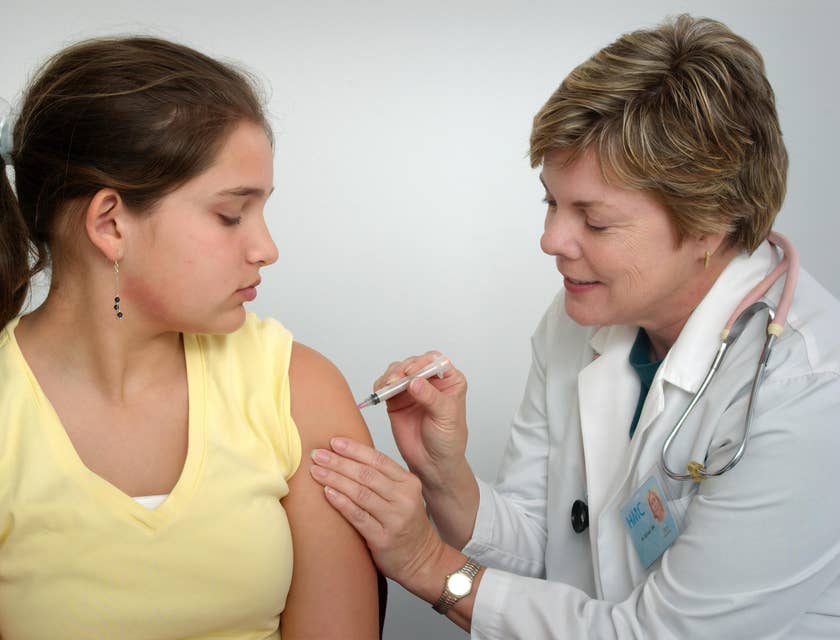 Uma médica injetando vacina em uma paciente em um centro médico.