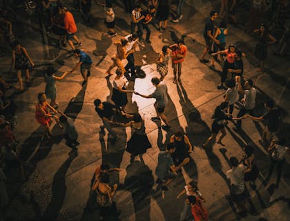 Grupo de gente reunida bailando salsa en una escuela de salsa.