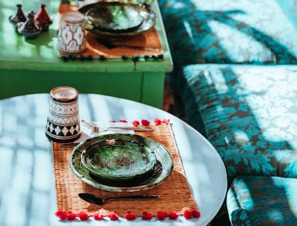 Tavoli e poltrone blu in stile marocchino con piatti in ceramica colorata nella sala di un ristorante marocchino.