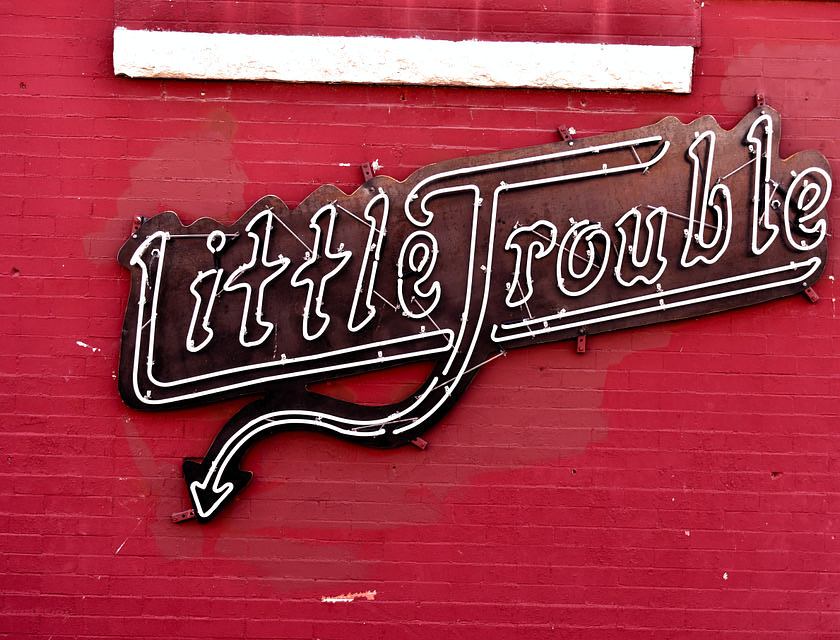 Enseigne commerciale au néon disant "Little Trouble".