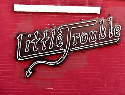 Enseigne commerciale au néon disant "Little Trouble".