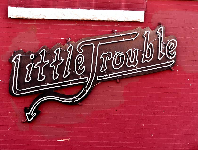 Letrero de neón "Little Trouble" para un negocio de nombre travieso