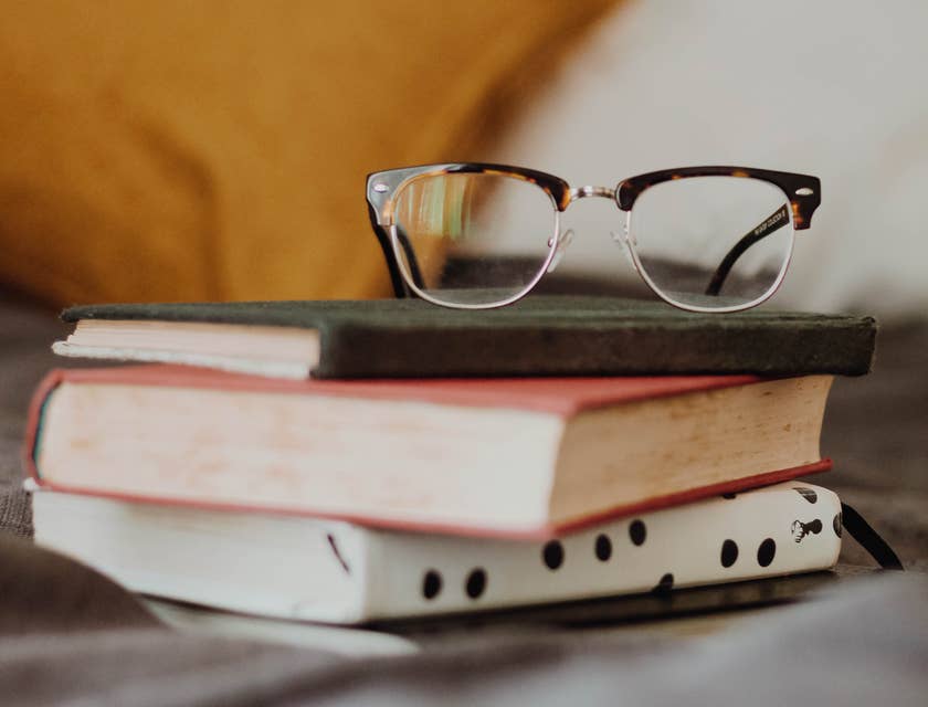 Una pila de libros con unos lentes encima en un negocio para nerds