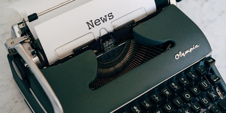 A typewriter printing a page with the headline "News."