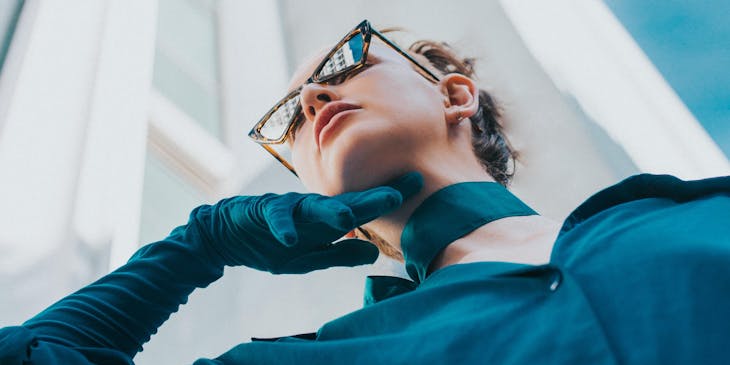 Woman wearing sunglasses and wearing a high class outfit.