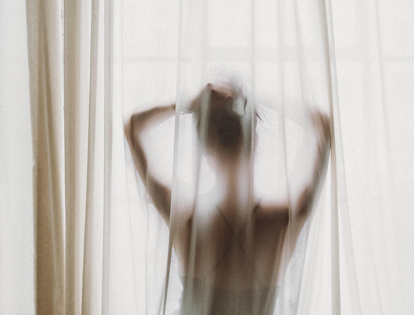 la silueta de una mujer posando frente a una ventana en un negocio erótico
