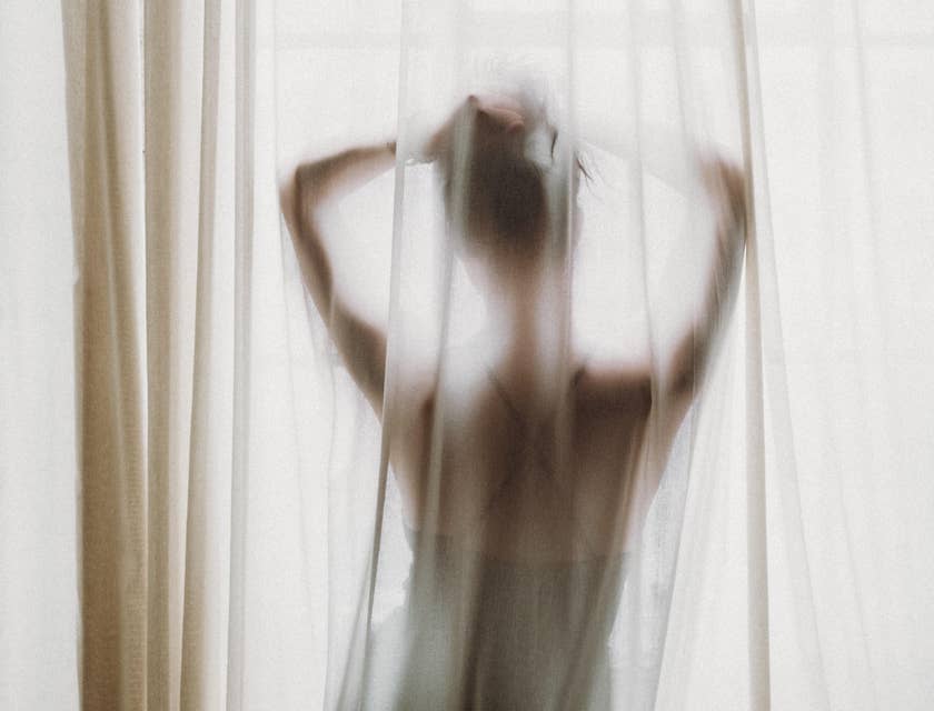 la silueta de una mujer posando frente a una ventana en un negocio erótico