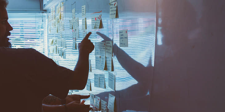 Una persona planeando una estrategia con ayuda de post its en un negocio estratégico.