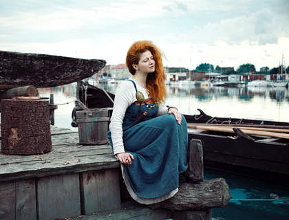 una mujer nórdica sentada en la costa de su ciudad admirando el paisaje en un negocio con nombre nórdico