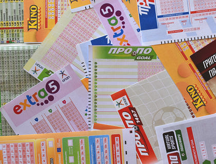 Boletos y planillas de lotería encimados unos con otros sobre una mesa en una administración de lotería