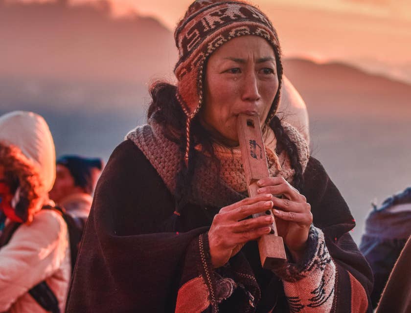 Una mujer tocando música típica de Bolivia en una agrupación boliviana.