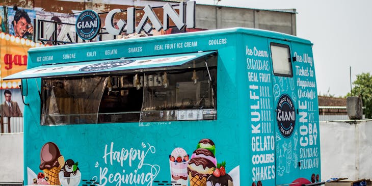 An attractive, brightly painted vehicle that functions as a food cart business.
