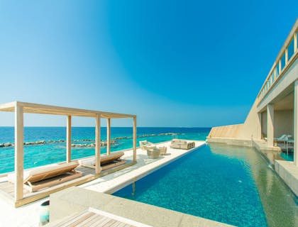 Una alberca frente al mar en una casa vacacional.