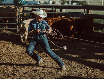 Un vaquero sosteniendo una soga en un club de rodeo.