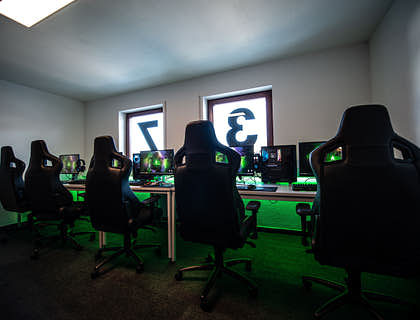 Interior de un club de juegos con sillas para gamer y computadoras.