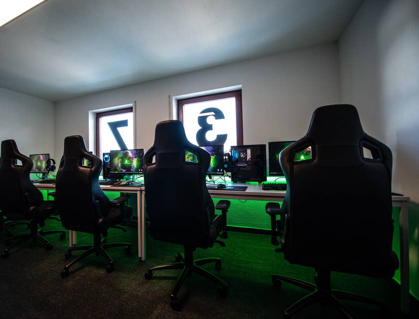 Interior de un club de juegos con sillas para gamer y computadoras.