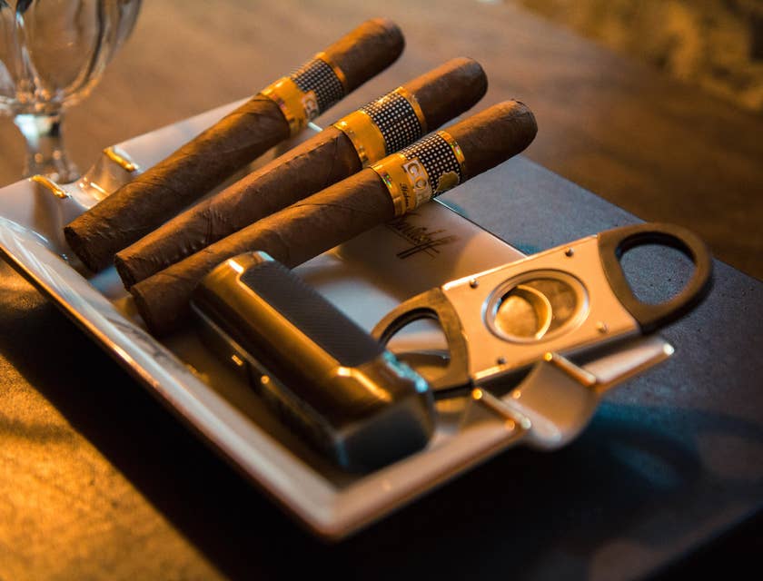 Tres puros acomodados sobre una mesa de madera en un curso de cata de puros.