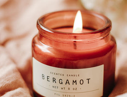 Una vela de soja color rosa y con aroma de bergamota en un negocio de emprendimiento de velas de soja.