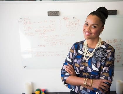 Una mujer frente a una pizarra blanca explicando su emprendimiento de mujer.