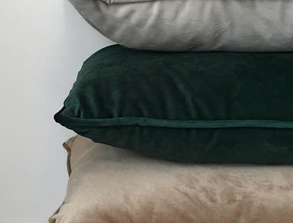 Tres almohadas apiladas una encima de otra con un fondo blanco en una empresa de almohadas.