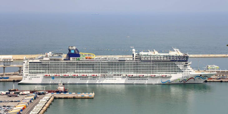 Un crucero, de una empresa de cruceros, estacionado en el puerto de una ciudad y esperando a que suban las personas.
