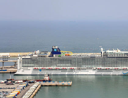 Un crucero, de una empresa de cruceros, estacionado en el puerto de una ciudad y esperando a que suban las personas.