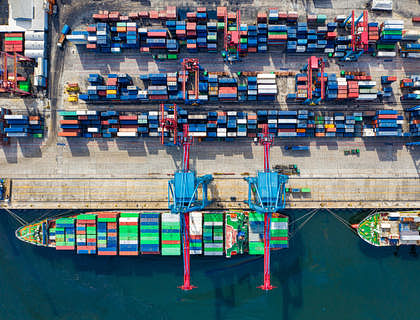 Barcos y contenedores en un puerto de una empresa de distribución.