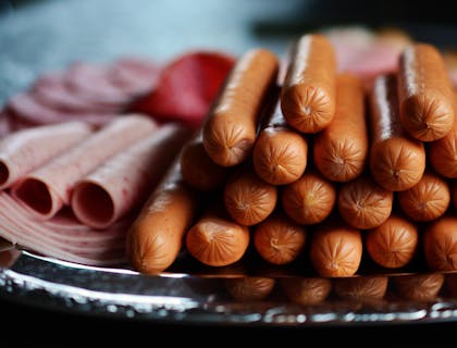 Salchichas, jamones y salami sobre un plato en una empresa de embutidos.