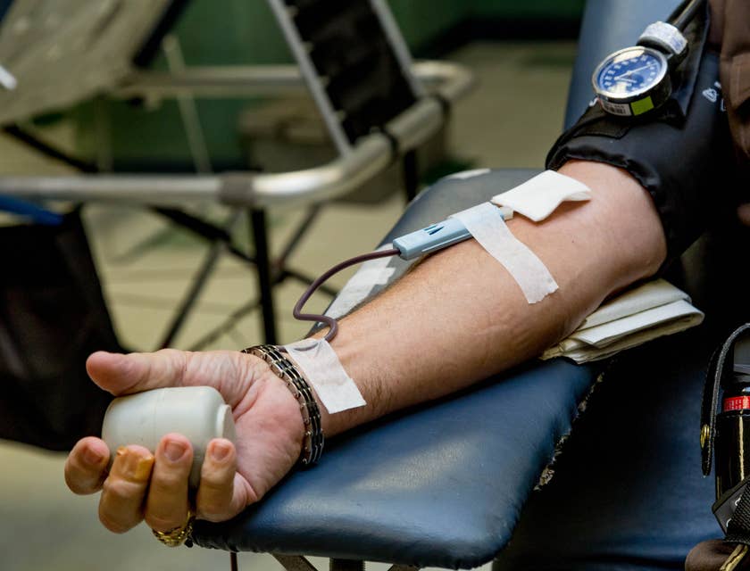 Brazo de un hombre canalizado para donar sangre en una empresa de hemoterapia.