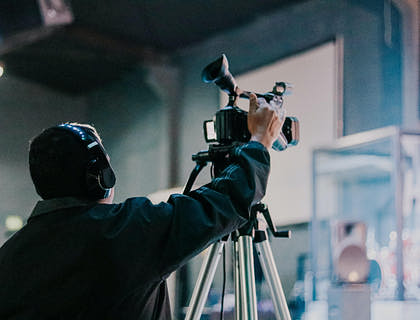 Un camarógrafo en medio de un estudio de grabación en una empresa de servicios audiovisuales.