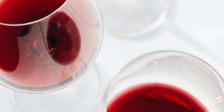 Tres copas servidas con vino de una empresa de vino de San Juan sobre un fondo blanco.