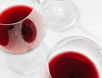 Tres copas servidas con vino de una empresa de vino de San Juan sobre un fondo blanco.