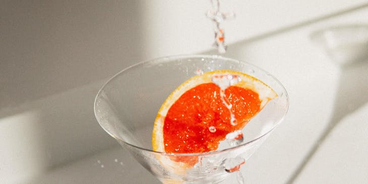 Un vodka martini con una rodaja de toronja siendo servido en el bar de una empresa de vodka.