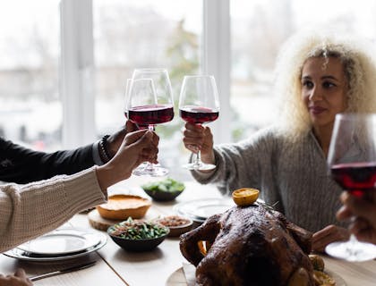 Una familia comiendo y brindando con vino en una enoteca.