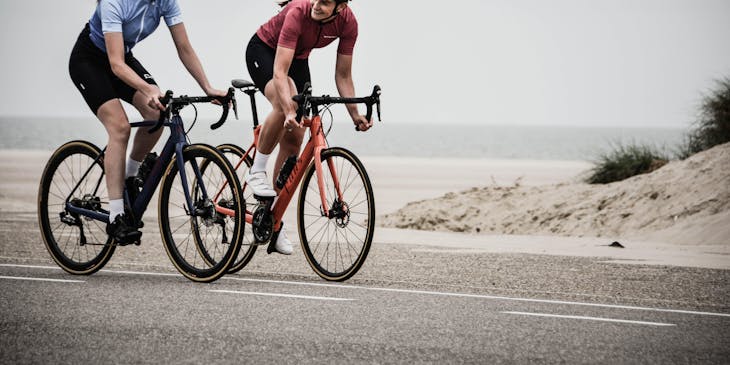 Dos mujeres ciclistas pertenecientes al mismo equipo de ciclismo.
