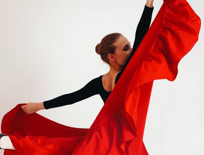 Una mujer bailando con una falda roja en una escuela de fandango.
