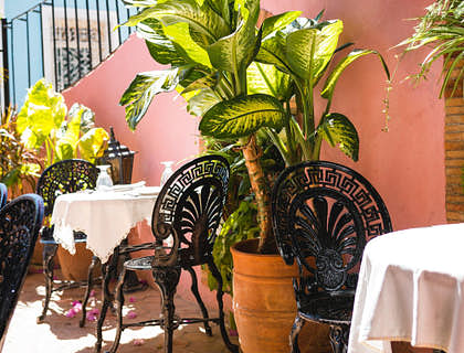 Mesas y sillas al aire libre en una fonda cubana.