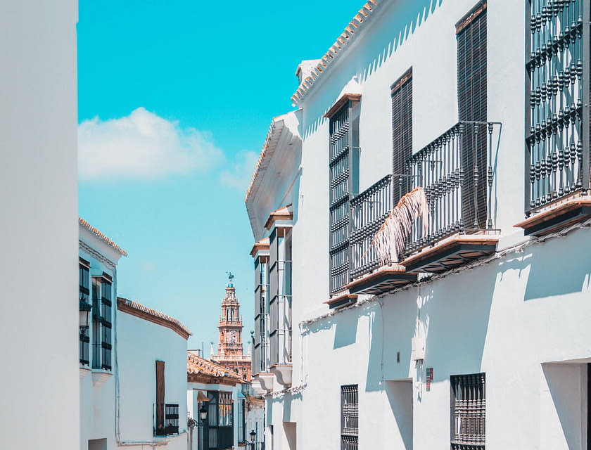 Calle empedrada con vista de una fonda española y una iglesia al fondo.