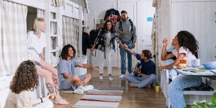 Un grupo de turistas compartiendo y conviviendo en el cuarto de un hostal.